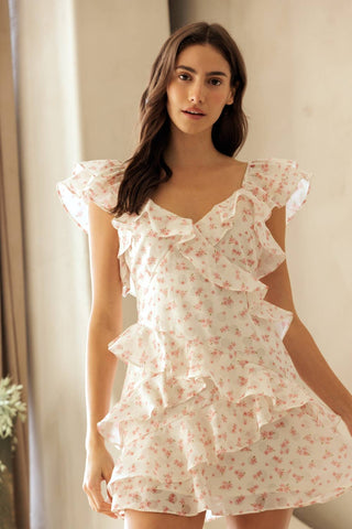 Woman wearing a floral pajama set in a softly lit room.