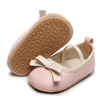 Pink baby shoes with a bow on a white background