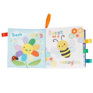 Two colorful soft books with a flower and bee design on a white background