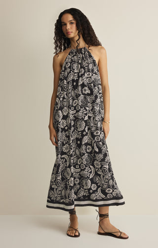 Woman wearing a black and white floral dress on a beige background