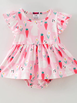Pink baby dress with bunny and carrot pattern on a light gray background