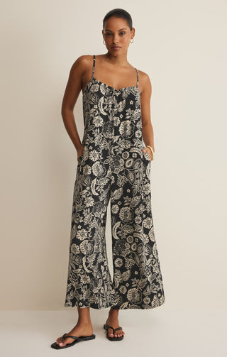Woman wearing a black and white floral patterned dress against a beige background