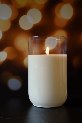 Candle in a glass container with a blurred bokeh background