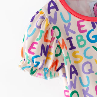 A close-up of a children's short-sleeve top with a cream base covered in colorful, hand-drawn style alphabet letters. The top features a bright coral-pink collar and ruffled sleeves.