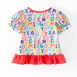 A children's short-sleeve top with a white base covered in colorful rainbow alphabet letters, featuring a red ruffled collar and a red ruffled hem, displayed on a clean white background.