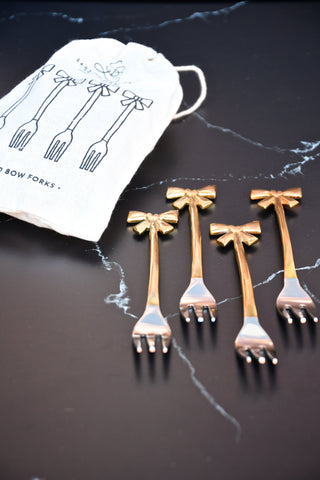 set of 4 small forks with gold bows on handle.