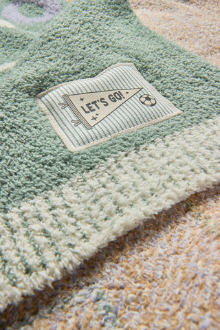 Textile product with a label reading 'Let's Go!' on a textured surface.