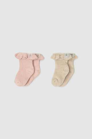 Two pairs of baby socks, one pink and one beige, on a light gray background.