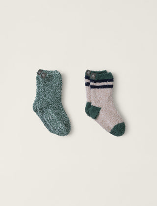Two pairs of socks, one green and one gray with stripes, on a beige background.