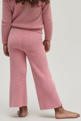 Person wearing a pink ribbed knit outfit on a white background