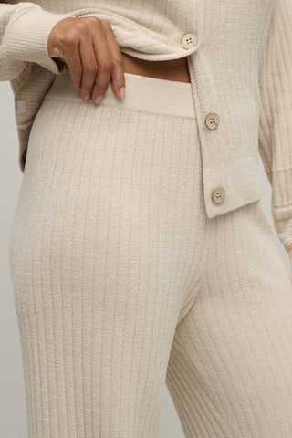 Beige ribbed sweater and pants set on a neutral background