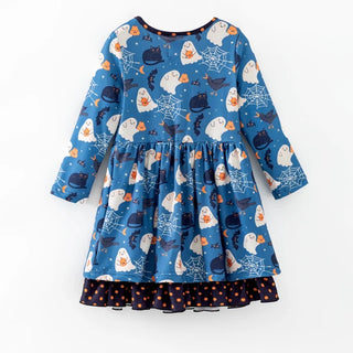A long-sleeve children's dress with a blue Halloween print featuring ghosts, bats, spiderswebs, and cauldrons, finished with a dark navy hem that has orange polka dots.