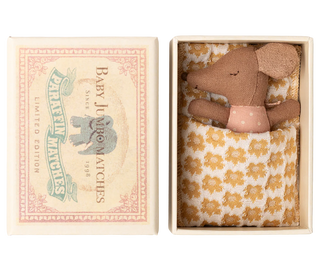 Small brown teddy bear in a decorative box with a floral pattern