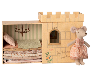 Wooden castle toy with bedding and a mouse doll in a dress on a white background