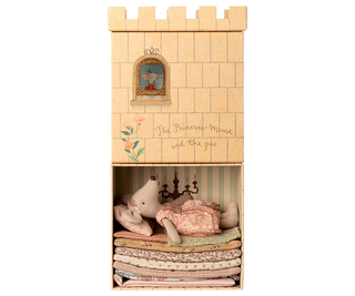 Wooden castle toy with a princess mouse and teddy bear inside on a white background