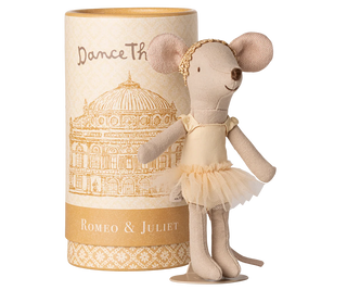 Stuffed mouse doll in a tutu dress next to a cylindrical box with decorative design and text.