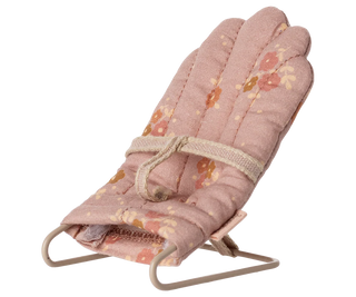 Floral patterned baby bouncer chair on a white background