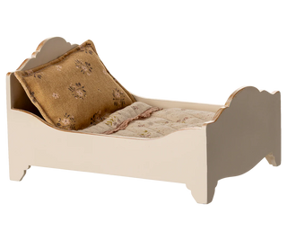 Small bed with a pillow and blanket on a white background