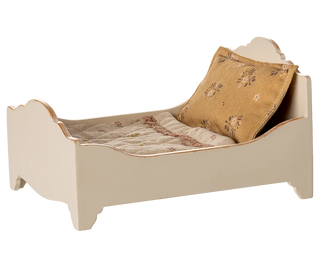 Small bed with bedding and a pillow on a white background