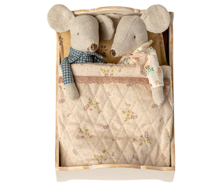 Two plush mouse toys in a wooden box with a quilted blanket