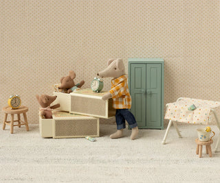 Miniature scene with a mouse character, teddy bears, and furniture in a room with beige walls and carpet.