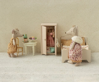 Miniature scene with toy mice in a room setting, including a wardrobe and furniture.