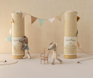Two toy mice with decorative boxes and a small chair on a neutral background
