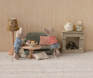 Two toy mice in a living room setting with furniture and decor.
