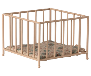 Beige metal crib with floral-patterned mattress on a white background
