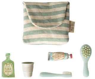 Set of eco-friendly products including a striped pouch, bottle, cup, tube, and brush on a white background.