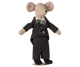 Stuffed toy mouse in a black suit with a bow tie on a white background