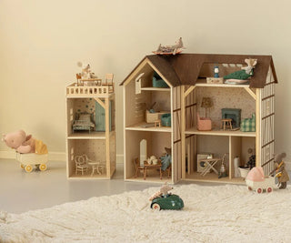 Wooden dollhouse with furniture and toys on a neutral background