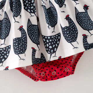 Baby romper with chicken pattern and red polka dot trim on a white background