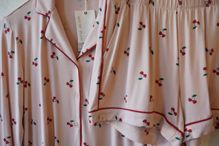 Pink pajama set with cherry pattern on a light background