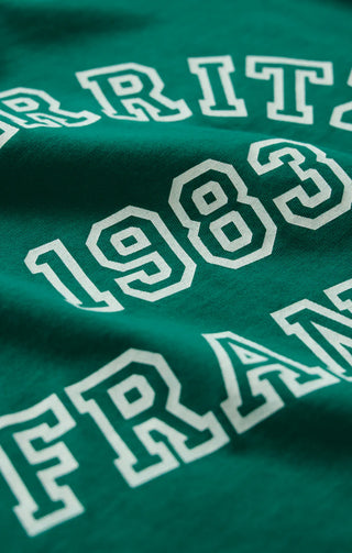 Green fabric with white text reading 'ERRITI 1983 FRAN'