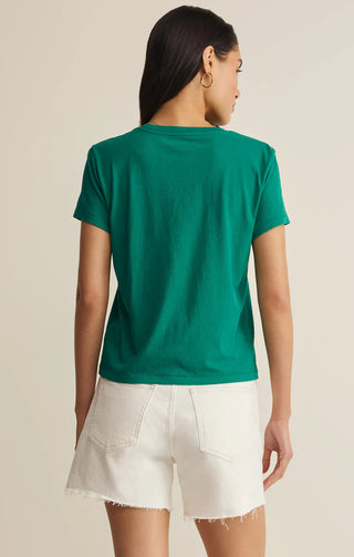 Person wearing a green t-shirt and white shorts on a beige background