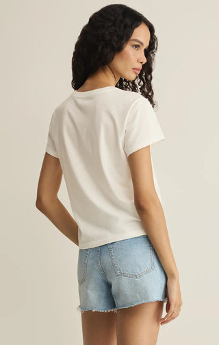 Woman wearing a white t-shirt and denim shorts on a beige background