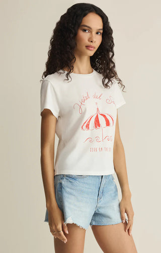 Woman wearing a white t-shirt with red graphic design on a beige background