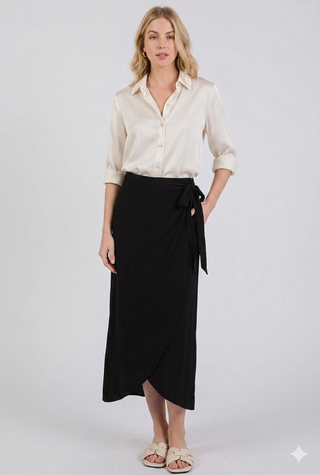 Woman wearing a white blouse and black wrap skirt on a white background