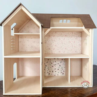 Wooden dollhouse with patterned wallpaper on a wooden surface