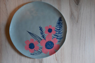 Round plate with floral design on a wooden surface