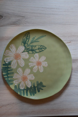 Decorative plate with floral design on a wooden surface