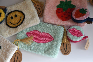 Collection of embroidered pouches with visible brand 'HM' on a white background