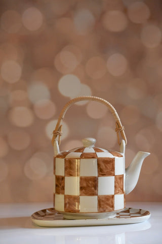 Checkered teapot with a wooden handle on a blurred background