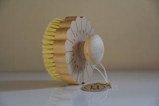 Decorative item with yellow bristles and white base on a beige background