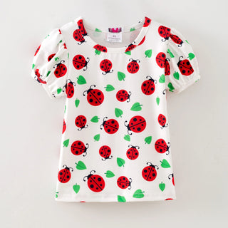 White t-shirt with red ladybug pattern on a white background