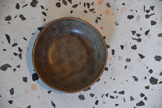 Brown ceramic bowl on a terrazzo countertop