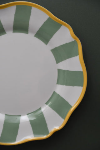 Ceramic plate with green and yellow design on a black background