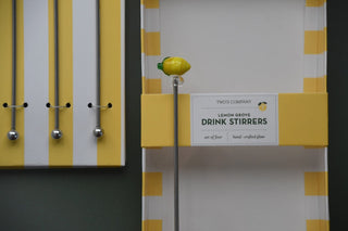 Packaging of drink stirrers with lemon design on a gray background