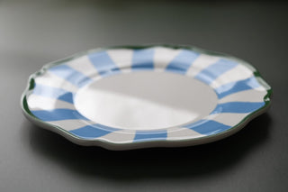 plastic plate with blue and white striped rim on a dark background